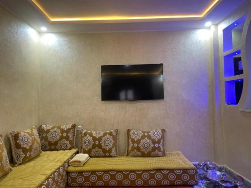 a living room with a couch and a flat screen tv at Residence el khanchi in Laayoune