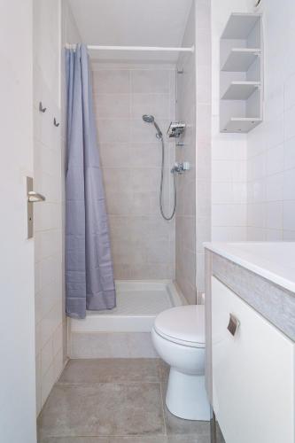 une salle de bain blanche avec toilettes et douche dans l'établissement Studio en bord de plage, à Villeneuve-Loubet