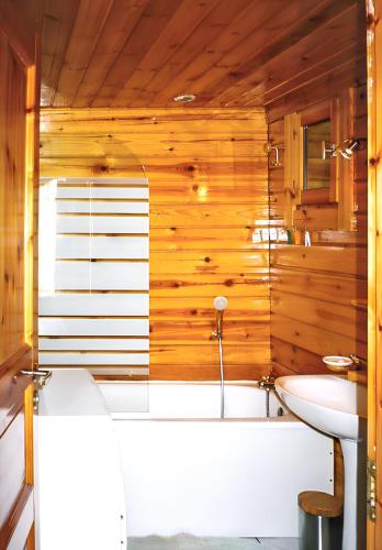 une salle de bain avec une baignoire et un lavabo dans l'établissement Chalet cosy à Sixt-Fer-à-Cheval avec vue sur la montagne, à Sixt-Fer-à-Cheval