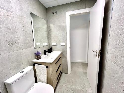 a bathroom with a toilet and a sink and a mirror at Valencia Getaway - Jacuzzi, Space & Comfort in Valencia