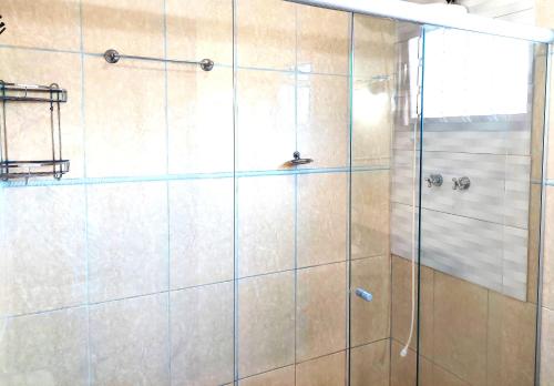 a bathroom with a shower with a glass door at Temporada Belas Casas in São Pedro