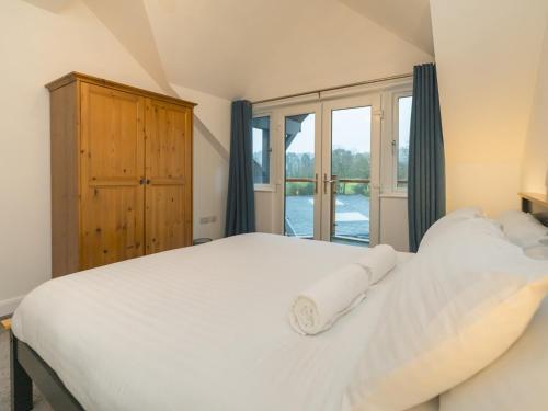 a bedroom with a large white bed and a window at Pass the Keys Modern 4-Bed Home Spacious & Comfortable in Pontesbury
