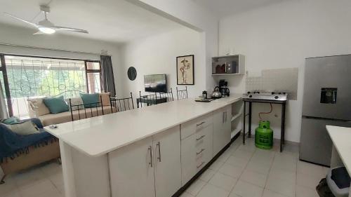 a kitchen with a white counter top and a refrigerator at Pumula on 5th in Pumula