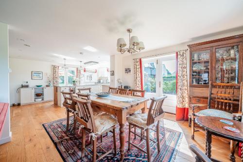 a kitchen and dining room with a wooden table and chairs at Beautiful Cottage in Brockenhurst with Forest View in Brockenhurst