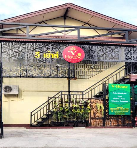 a building with a sign on the side of it at Manu V House in Phra Nakhon Si Ayutthaya