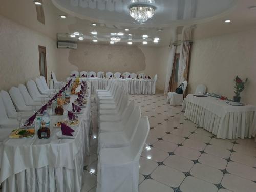 a banquet hall with white tables and white chairs at Racu in Komrat