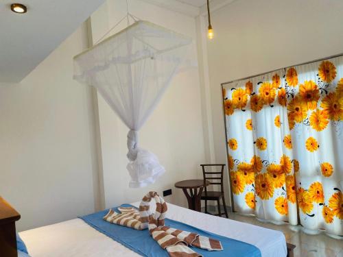 a room with a bed with a curtain and an umbrella at The Pearl Villa Ahangama in Ahangama