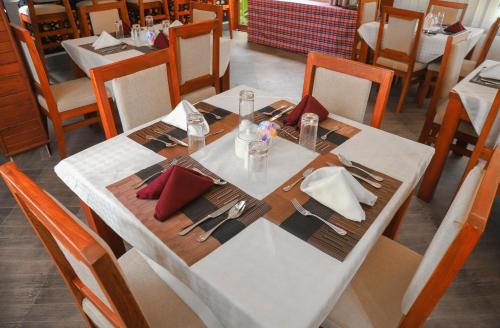 a table in a restaurant with a white table cloth and sidx sidx sidx at River House Lodge International in Arusha