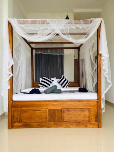 a canopy bed with two pillows on top of it at Belmount Ella in Ella