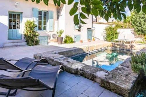 un patio avec des chaises et une piscine dans l'établissement La Provence centre ville, piscine, jardin, terrasse, à Nîmes