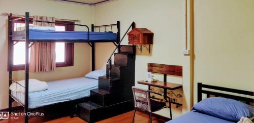 a room with two bunk beds and a table at Manu V House in Phra Nakhon Si Ayutthaya