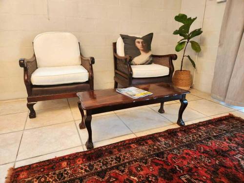 a living room with two chairs and a coffee table at This Is Not The Post Office in Riebeek-Kasteel