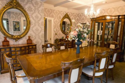 a dining room with a wooden table and mirrors at Private Country Residence Made 4 Luxury Gathering in Newcastle West