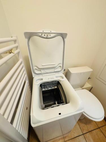 une petite salle de bain avec des toilettes avec leur couvercle relevé dans l'établissement Appartement Vu Mont Blanc parking Terrasse, à Chamonix-Mont-Blanc