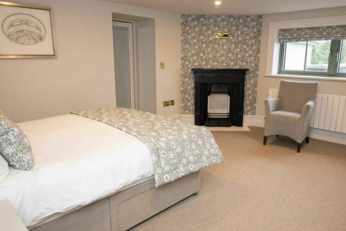 a bedroom with a bed and a fireplace and a chair at Private Country Residence Made 4 Luxury Gathering in Newcastle West