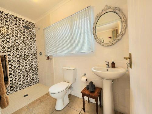 a bathroom with a toilet and a sink and a mirror at This Is Not The Post Office in Riebeek-Kasteel