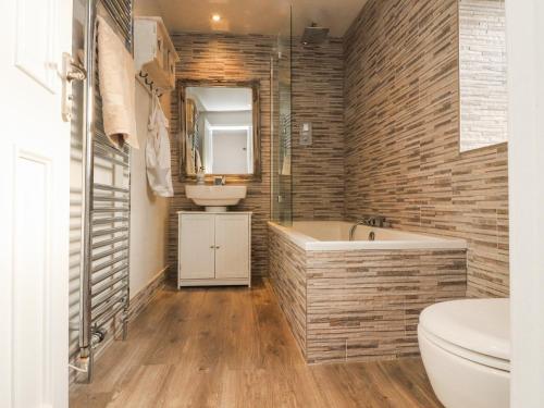 a bathroom with a tub and a sink at Chapel Croft in Skipton