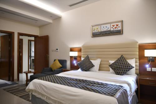 een hotelkamer met een groot bed en een stoel bij بيستانا للشقق المخدومة 2 in Riyad