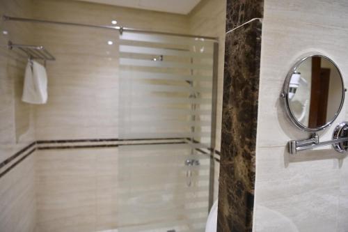 een badkamer met een douche en een spiegel bij بيستانا للشقق المخدومة 2 in Riyad