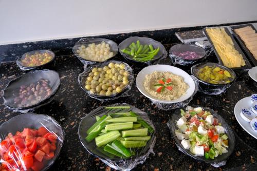 a group of bowls of different types of food on a counter at Pyramids Height Hotel & Pyramids Master Scene Rooftop in Cairo