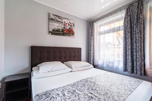 a bedroom with a bed and a window at Domki Letniskowe Bursztynek in Grzybowo