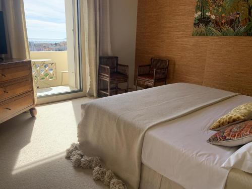 une chambre avec un lit et une grande fenêtre dans l'établissement MV Gallery Collection, Beau Bourgeois vue Mer, à Cannes