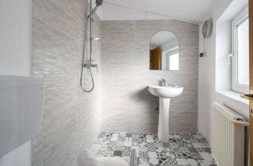 a white bathroom with a sink and a shower at Flowers Grand Hotel Bucharest in Bucharest