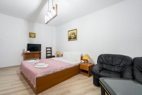 a small bedroom with a bed and a couch at Flowers Grand Hotel Bucharest in Bucharest
