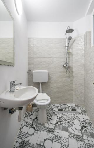a bathroom with a toilet and a sink at Flowers Grand Hotel Bucharest in Bucharest