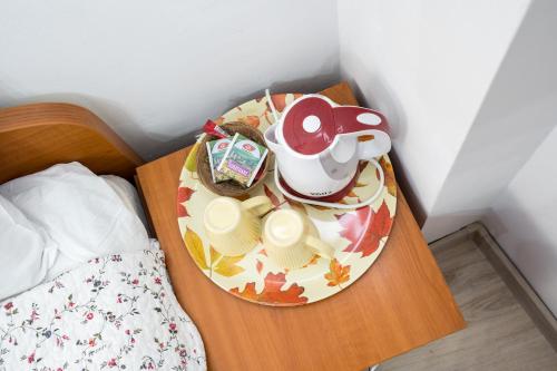 a table with a tea pot on it next to a bed at Flowers Grand Hotel Bucharest in Bucharest