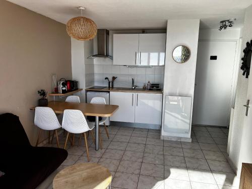 une cuisine et une salle à manger avec une table et des chaises dans l'établissement Appartement vue mer Valras plage, à Valras-Plage