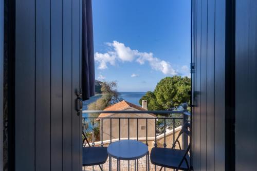 a room with a view of the ocean from a balcony at Vina's Stone House in Limeni