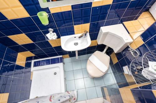 a bathroom with a blue and yellow tiled wall at Flowers Grand Hotel Bucharest in Bucharest