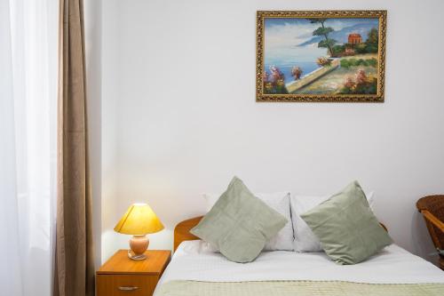 a bedroom with a bed with a painting on the wall at Flowers Grand Hotel Bucharest in Bucharest