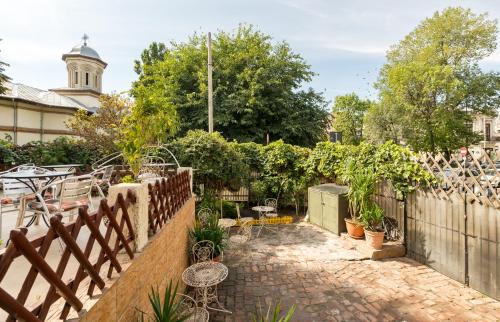 a garden with a fence and a patio with plants at Flowers Grand Hotel Bucharest in Bucharest