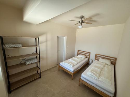 a bedroom with two beds and a ceiling fan at Simanić Apartments in Malinska