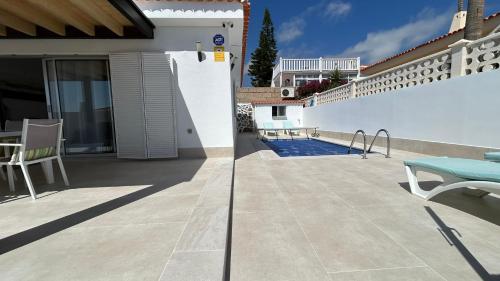 a patio with a table and chairs on a house at Ocean Vibes with sea view and private heated pool in Callao Salvaje