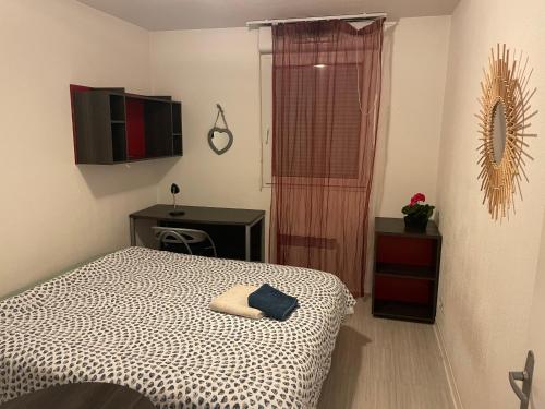 une chambre avec un lit, un bureau et une télévision dans l'établissement Joli appartement sur Aix-en-Provence, à Aix-en-Provence