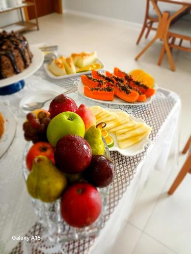 a table topped with plates of fruit and cheese at Pousada Ametista - Penha, SC - 1,5 km do Parque Beto Carrero World in Penha