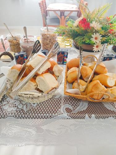 two baskets of sandwiches and utensils on a table at Pousada Ametista - Penha, SC - 1,5 km do Parque Beto Carrero World in Penha