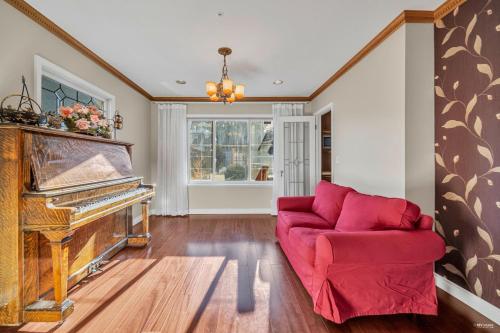 un soggiorno con un divano rosso e un pianoforte di Cozy Dunbar 3 Beds Home w/ Views a Vancouver