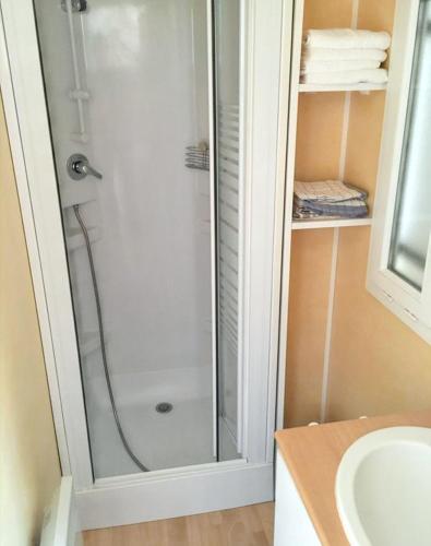 une douche avec une porte vitrée dans une salle de bain dans l'établissement Bungalow paisible à Cauterets, à Cauterets