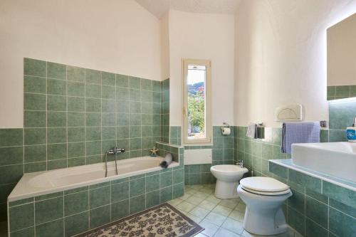 a bathroom with a tub and a toilet and a sink at Villa Corallo in Costa Rei