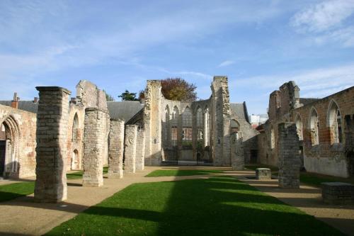 an old castle with columns in the grass at Cosy homestay in Quiet historic area in Tienen