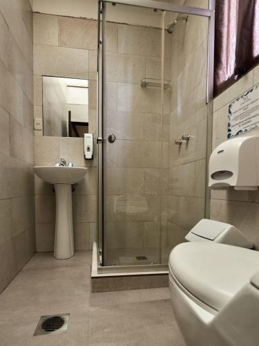 a bathroom with a shower and a toilet and a sink at Wild Rover La Paz in La Paz
