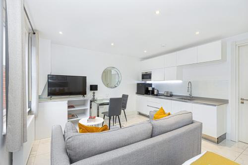 a living room with a couch and a kitchen at Harley Street Luxury Apartments by City Relay in London
