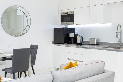 a living room with a couch and a kitchen at Harley Street Luxury Apartments by City Relay in London