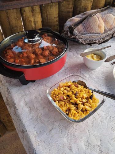 a table with a pot of food and a plate of food at Chalés do Caminho - Afeto in Ritápolis