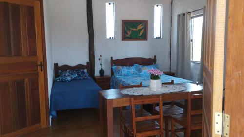 a bedroom with a bed and a table and a table sidx sidx sidx at Chalés do Caminho - Afeto in Ritápolis