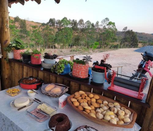 a table with vegetables and other foods on it at Chalés do Caminho - Afeto in Ritápolis